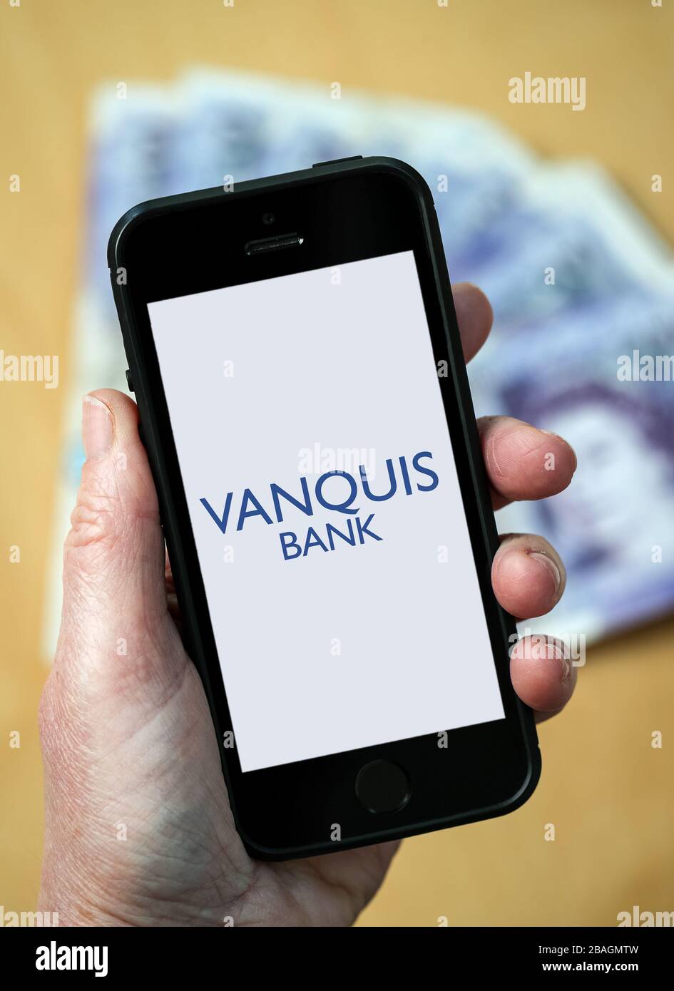 Eine Frau, die das Logo der Vanquis Bank auf einem Mobiltelefon betrachtet. (Nur redaktionelle Verwendung) Stockfoto