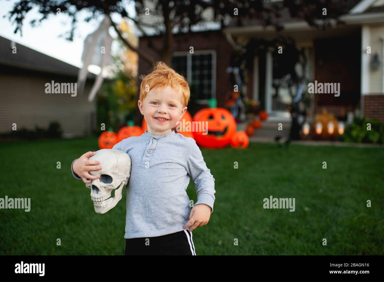 Kleinkind Junge lächelnd, während die halloween-Dekor im Vorgarten Stockfoto