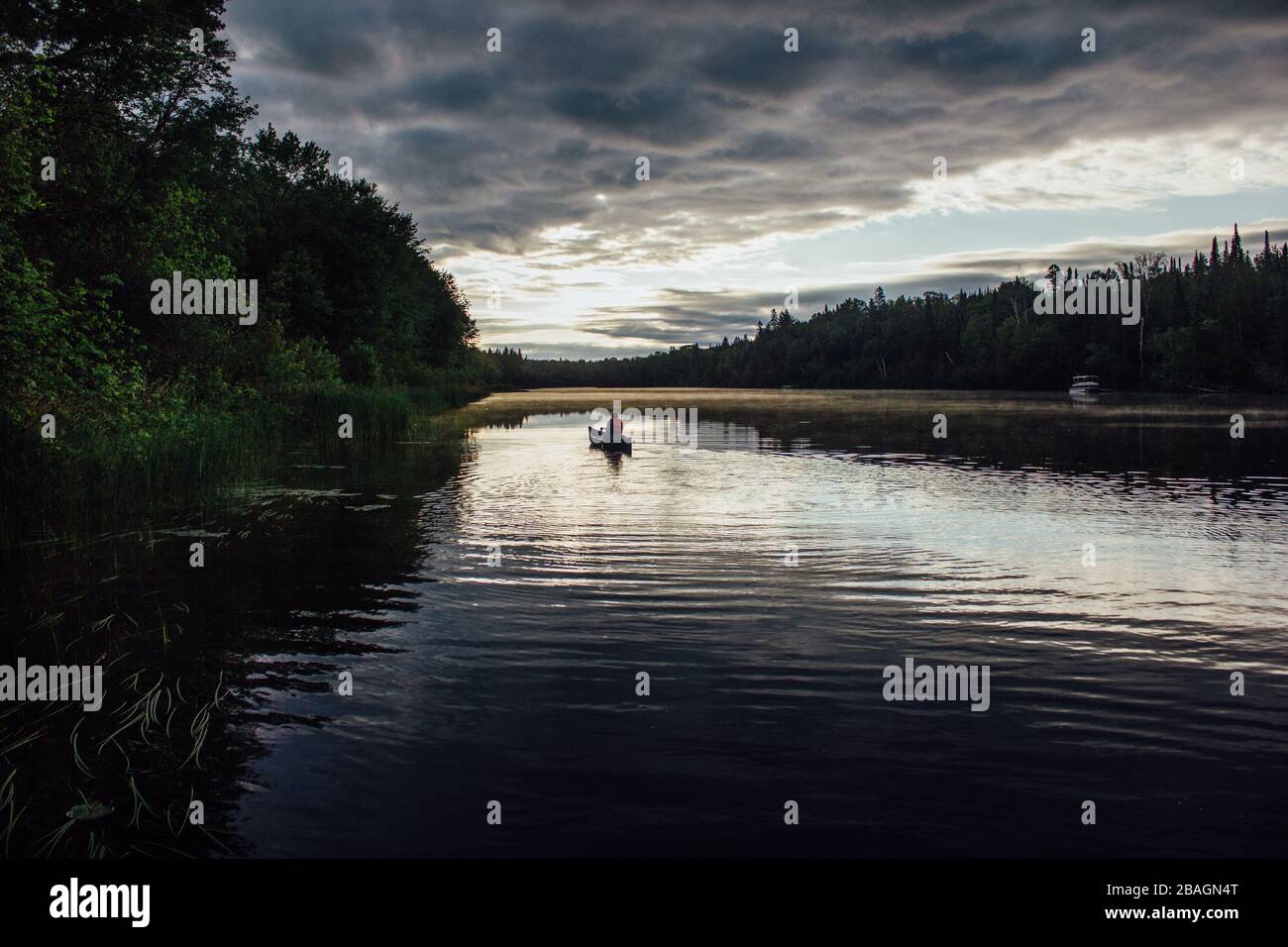 Mann Kanufahren bei Sonnenaufgang auf dem Fluss im Norden Kanadas Stockfoto