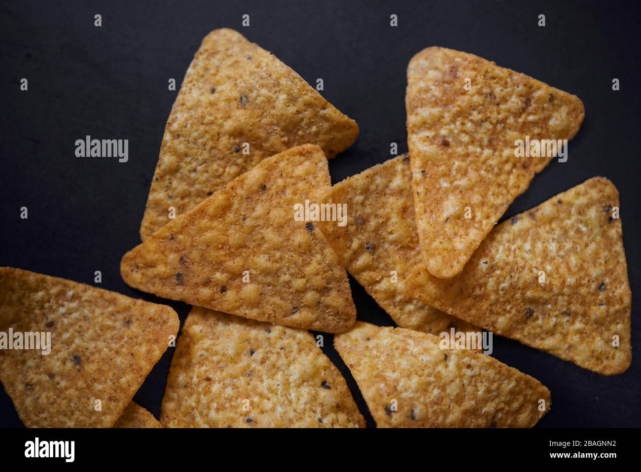Draufsicht auf würzigen Tortilla Chips auf dem schwarzen Boden Stockfoto
