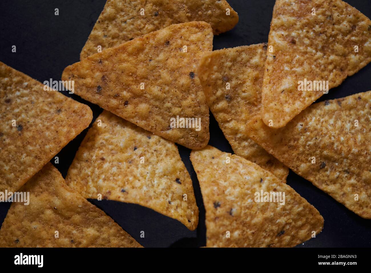 Draufsicht auf würzigen Tortilla Chips auf dem schwarzen Boden Stockfoto