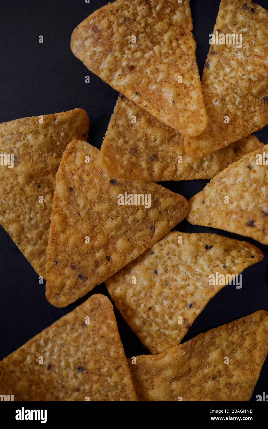 Draufsicht auf würzigen Tortilla Chips auf dem schwarzen Boden Stockfoto