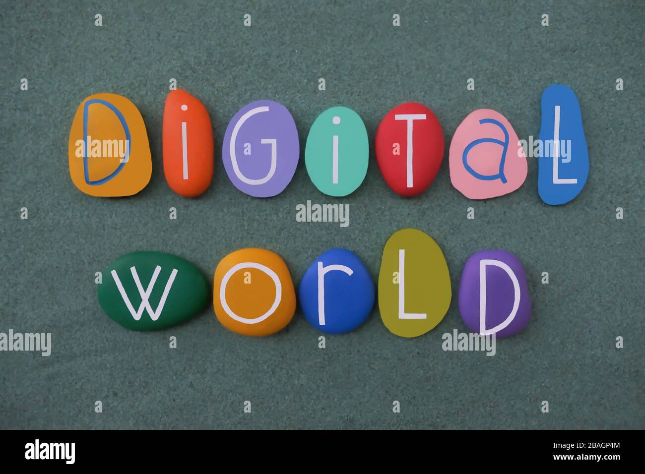 Digital World Text mit mehrfarbigen Steinbuchstaben über grünem Sand Stockfoto