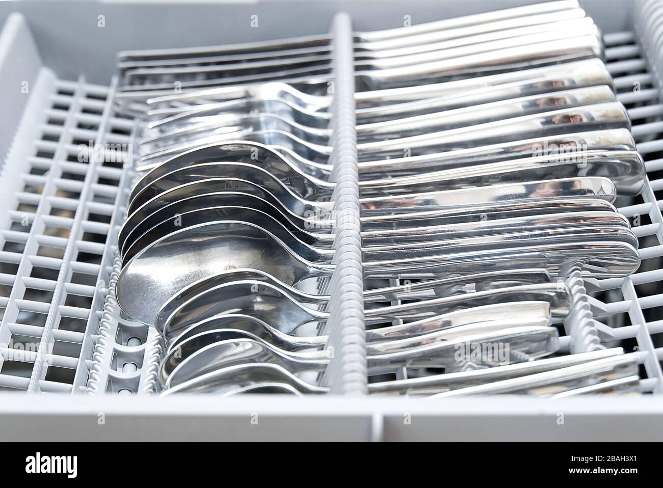 Sauberes Besteck befindet sich im Geschirrspüler. Nahaufnahme Stockfoto