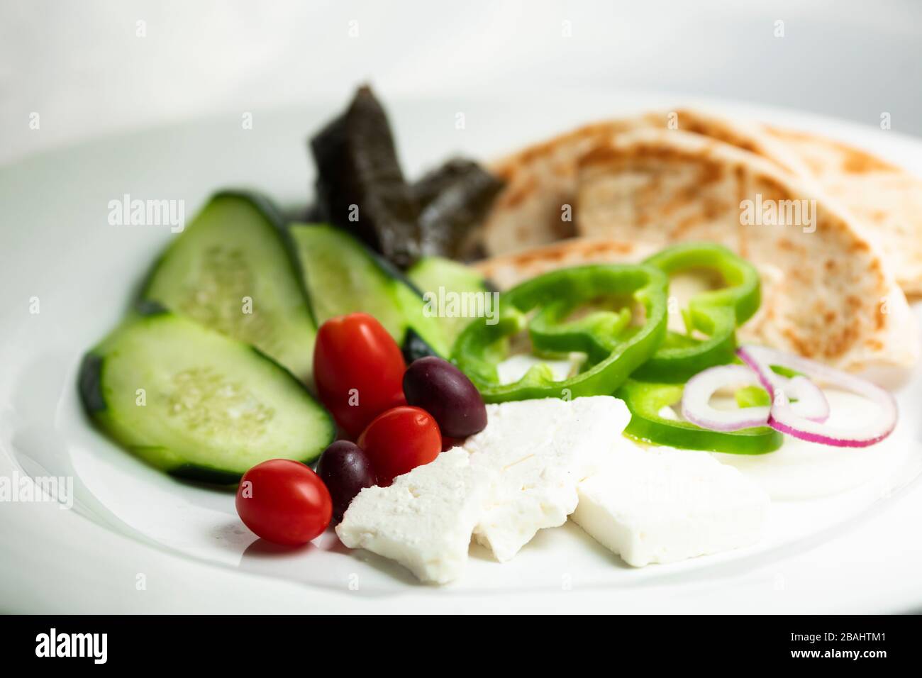 Griechische Meze Lebensmittel Platte; mit Gemüse, Pita, Feta und Traubenblättern Stockfoto
