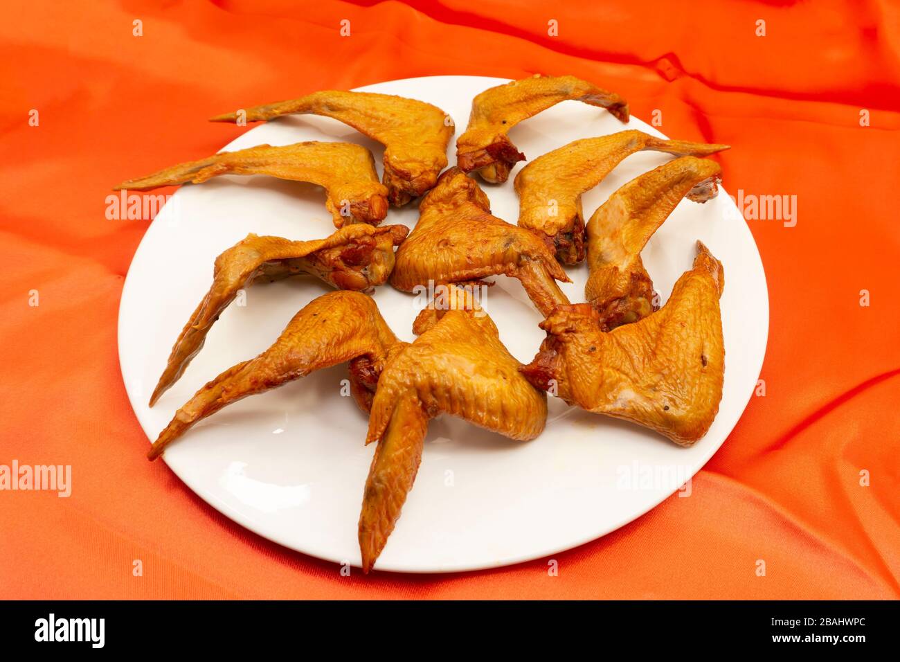 Warme Gerichte - gegrillte Hühnerflügel mit roter heißer Soße. Stockfoto