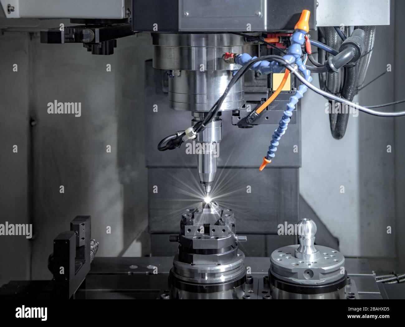 CNC-Fräsmaschine mit hoher Präzision, Bearbeitung von Metallteilen durch den Bediener im Werk Stockfoto