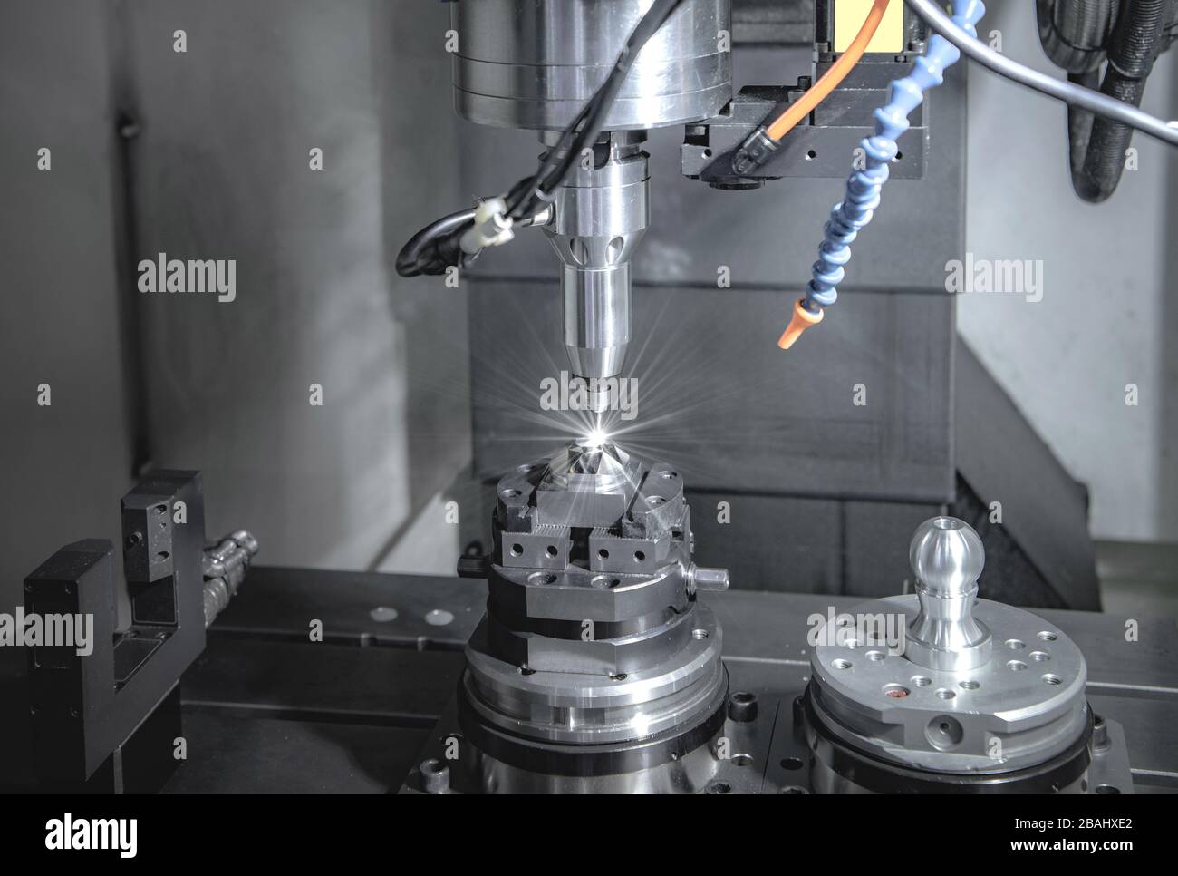 CNC-Fräsmaschine mit hoher Präzision, Bearbeitung von Metallteilen durch den Bediener im Werk Stockfoto