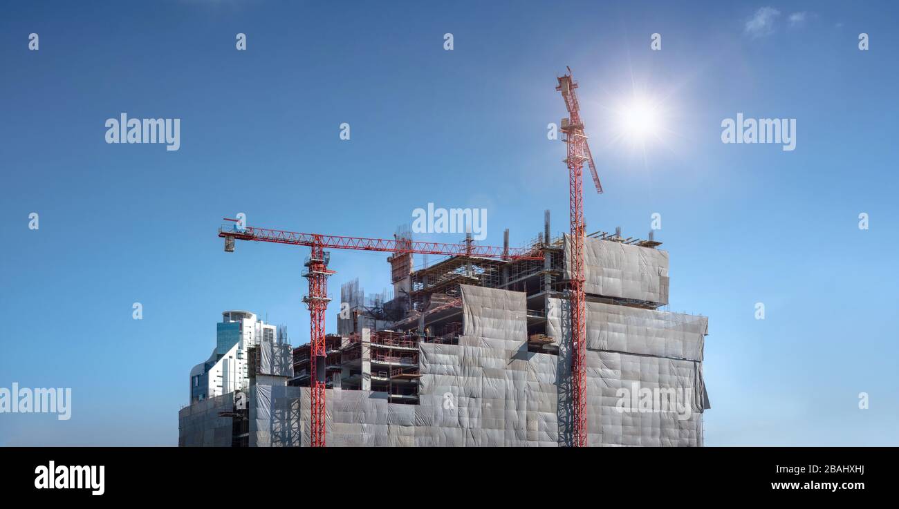 Panoramaansicht bei den Arbeitern auf großen Baustellen und viele Kräne arbeiten im Industrieneubaugeschäft. Stockfoto