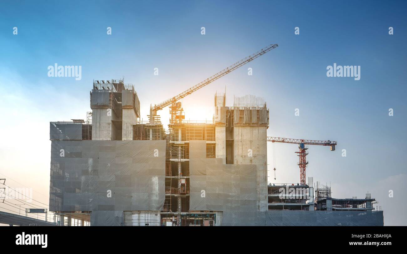 Panoramaansicht bei den Arbeitern auf großen Baustellen und viele Kräne arbeiten im Industrieneubaugeschäft. Stockfoto