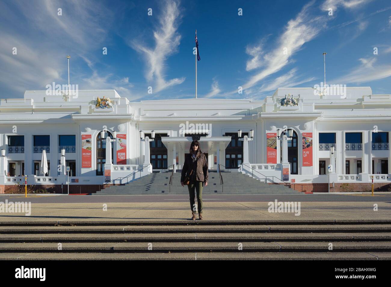 Weiblicher Tourist, der auf der Treppe steht, die zum Eingang des Old Parliament House in Canberra, Australian Capital Territory, führt. Stockfoto