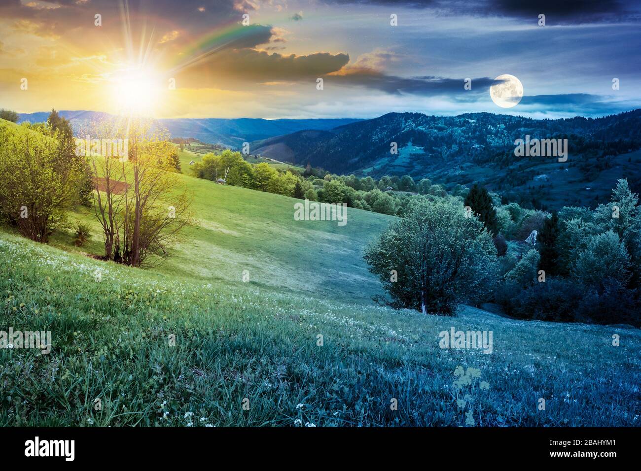 Zeitwechsel über der ländlichen Landschaft in den Bergen. Landschaft bei übergiebeltem Wetter im Frühling mit Sonne und Mond. Tag und Nacht wechseln sich ab Stockfoto