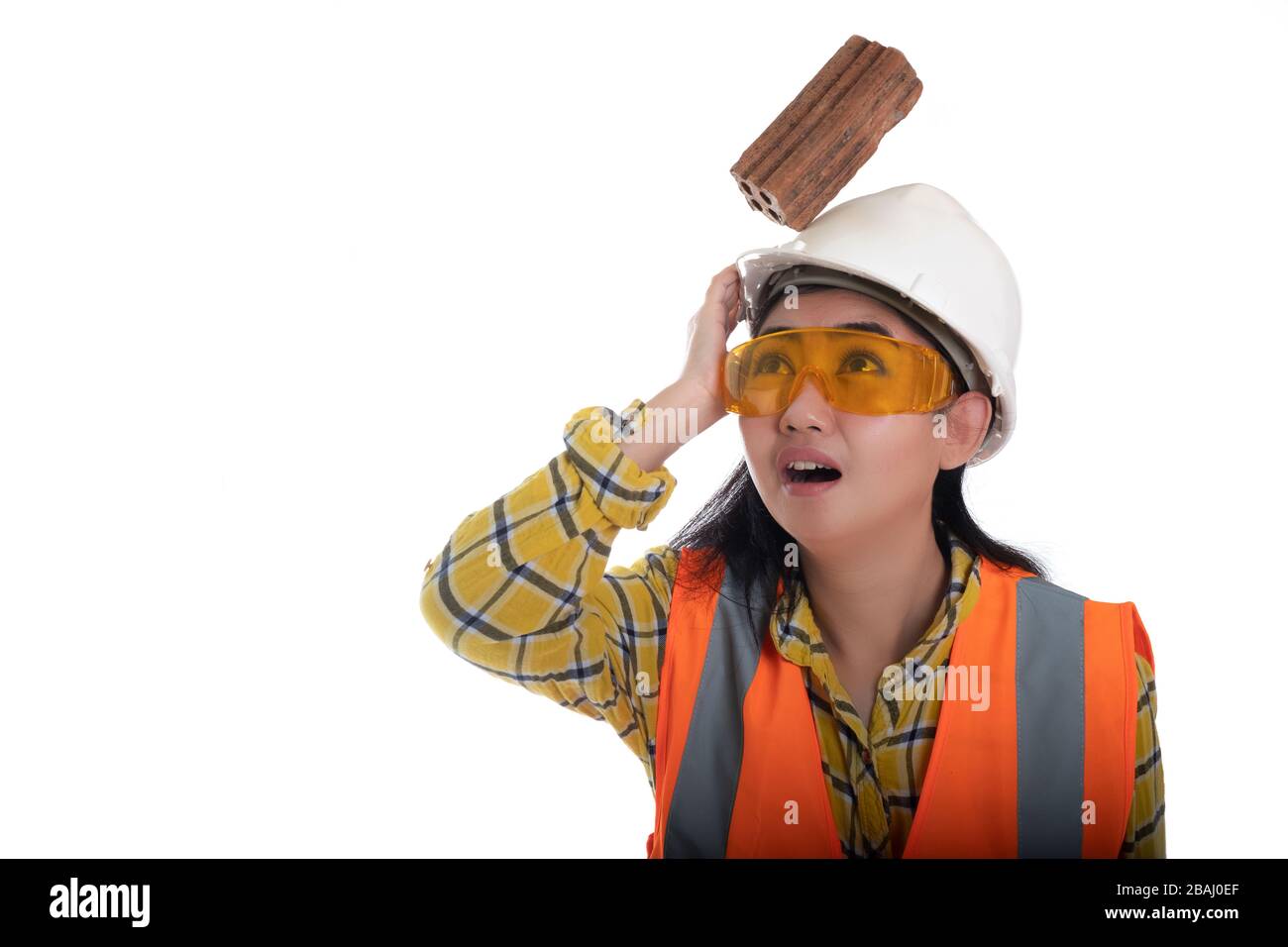 Der Backstein aus dem Knüppel fiel auf die junge Frau des Asien-Ingenieurs, die mit weißem Hintergrund auf die Helmpfachterin aufschlug, Area Construction Safety First Concept Stockfoto