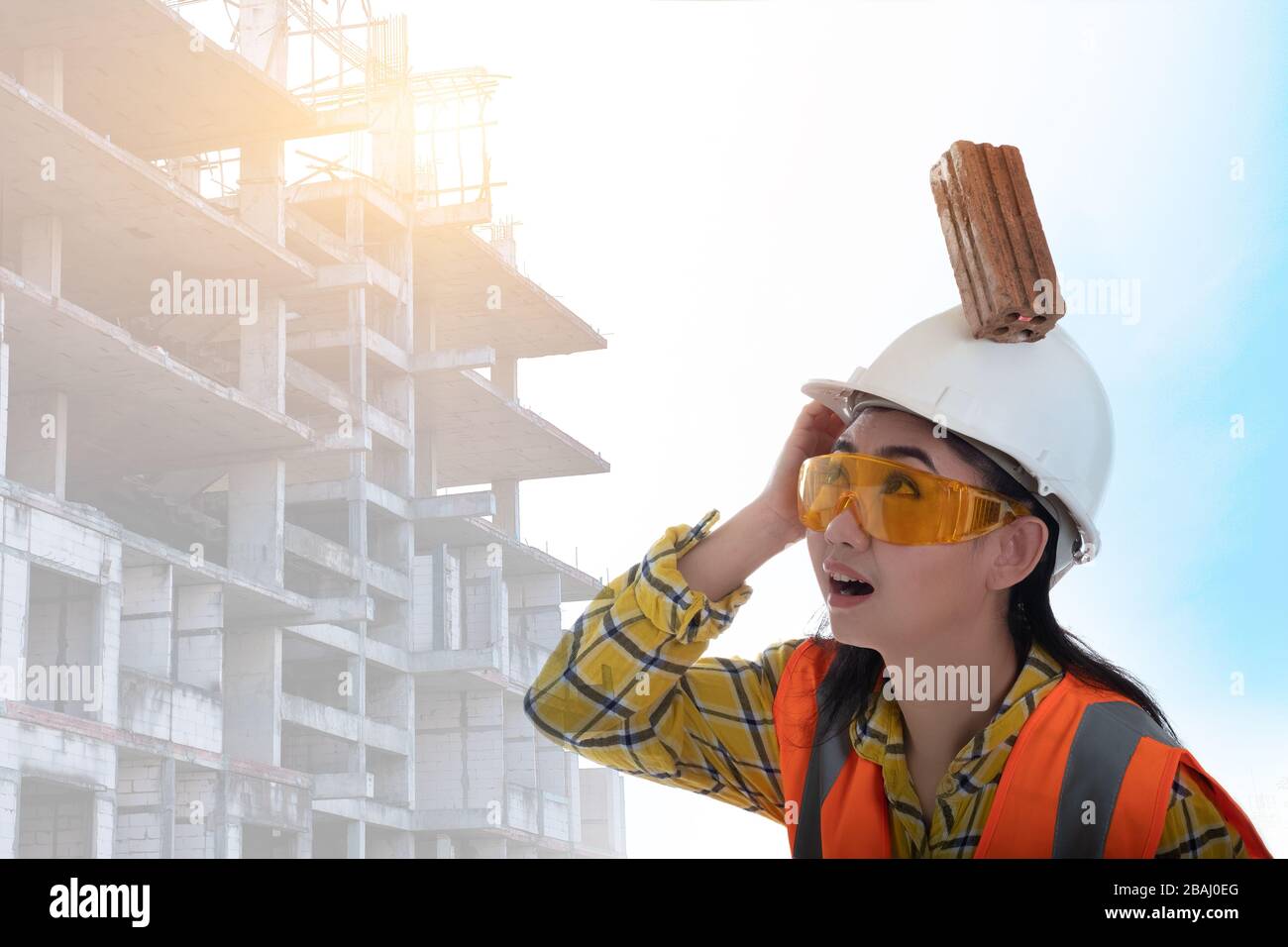 Der Backstein aus dem Knüppel fiel auf die junge Frau des Asien-Ingenieurs, die mit weißem Hintergrund auf die Helmpfachterin aufschlug, Area Construction Safety First Concept Stockfoto