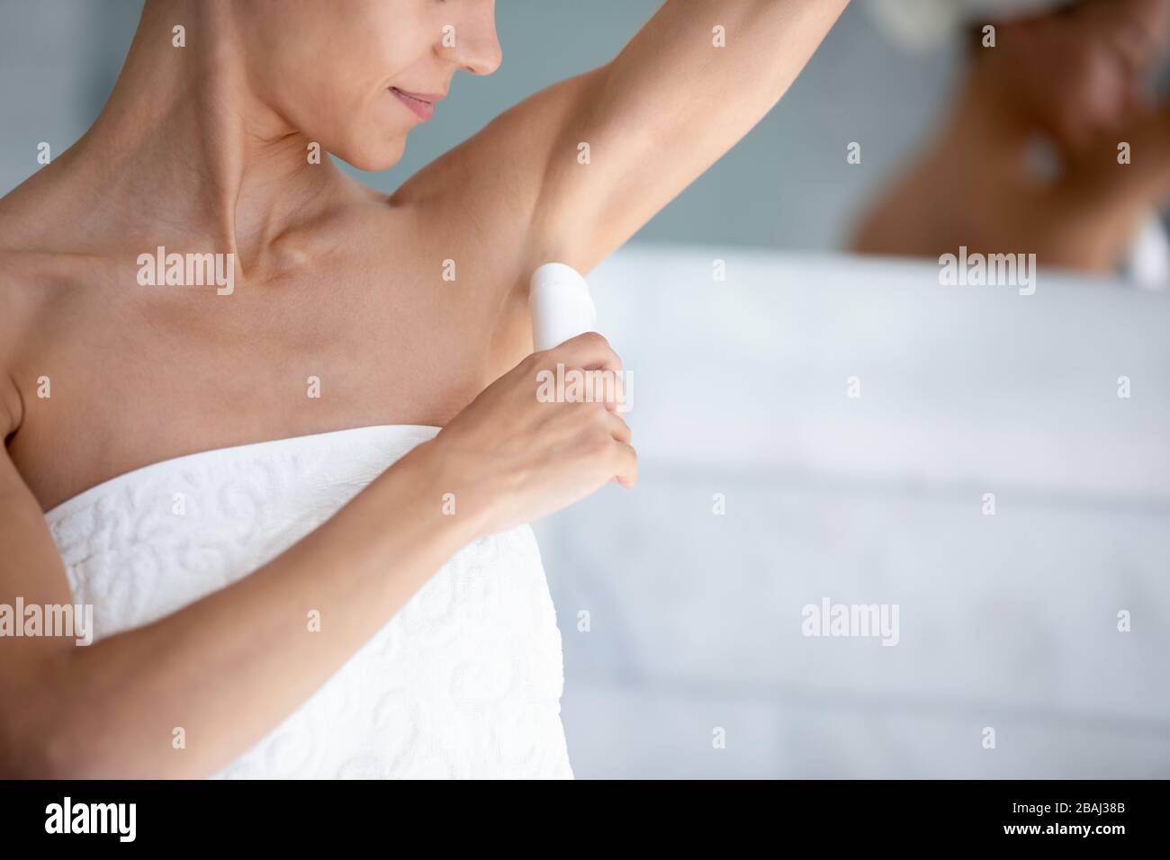 Frau wendet Antitranspirant an, nachdem sie im Nahbild am Morgen geduschen war Stockfoto