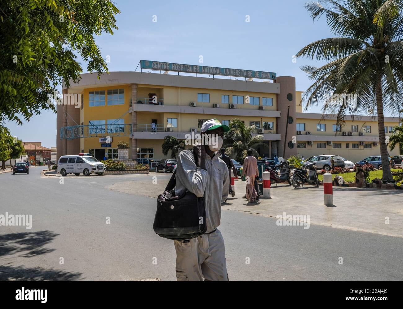 Dakar, Senegal. März 2020. Ein Mann mit Schutzmaske läuft am Eingang des Fann Krankenhauses in Dakar, Senegal, am 27. März 2020 vorbei. Der senegalesische Minister für Gesundheit und soziale Aktion Abdoulaye Sarr berichtete am Freitag von 14 neuen bestätigten Fällen der COVID-19, was die Gesamtzahl des Landes auf 119 brachte. Kredit: Eddy Peters/Xinhua/Alamy Live News Stockfoto