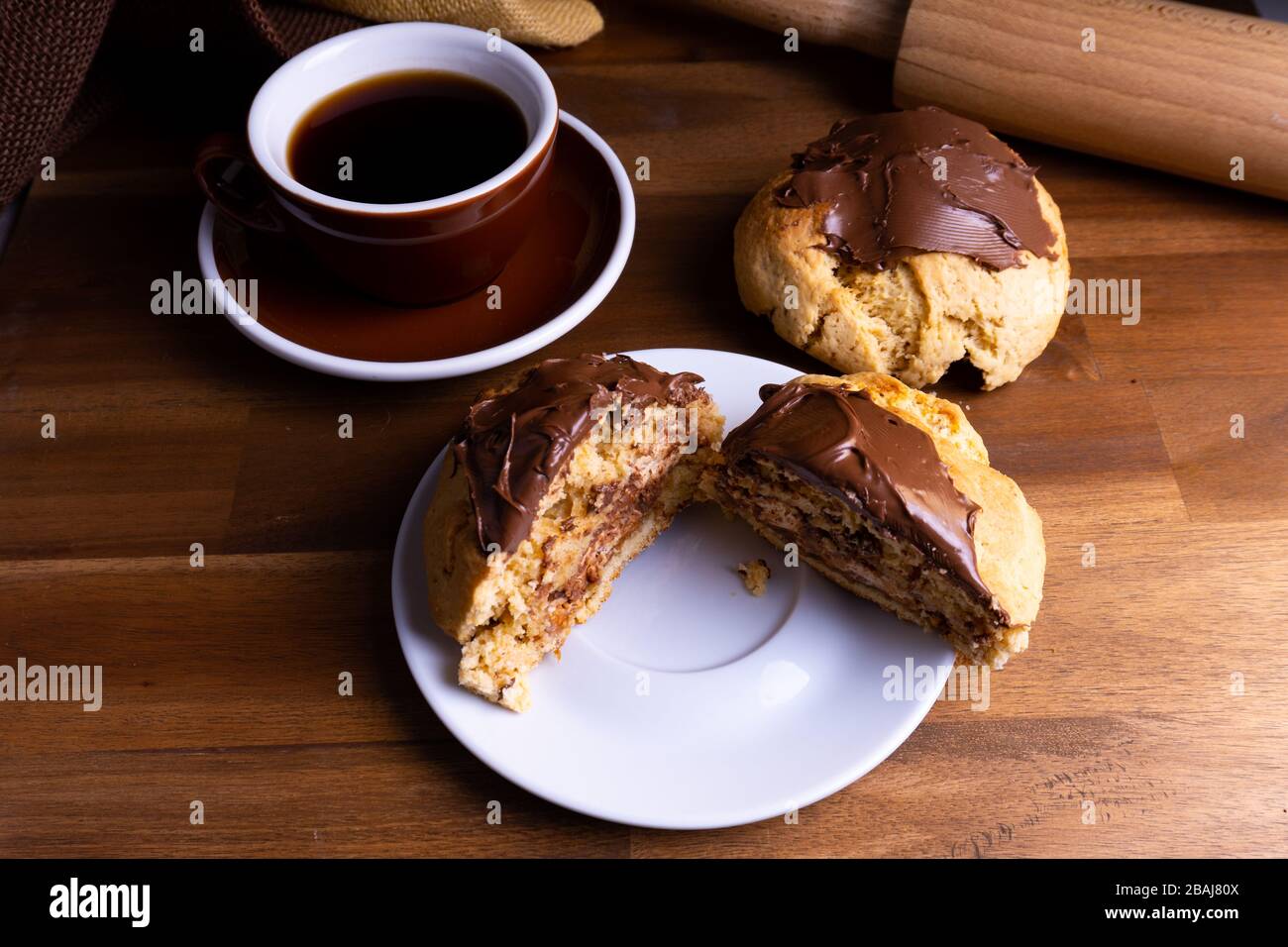 Köstliche Plätzchenkuchen mit Schokolade mit einer Tasse Kaffee auf einem Holzbrett mit Kopierraum Stockfoto