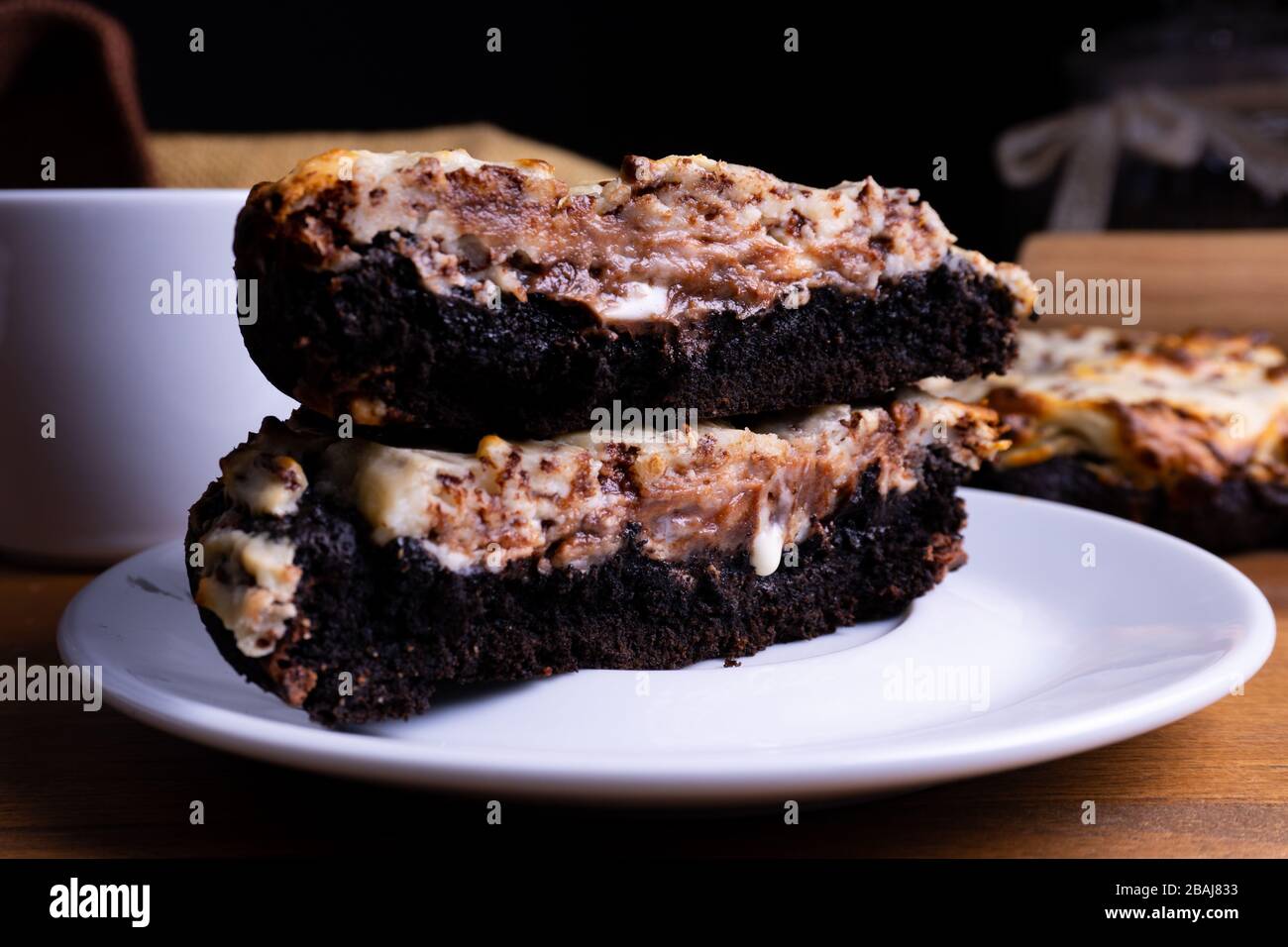 Köstliche Plätzchenkuchen mit Schokolade und Käsekuchen mit einer Tasse Kaffee auf einem Holzbrett mit Kopierraum Stockfoto