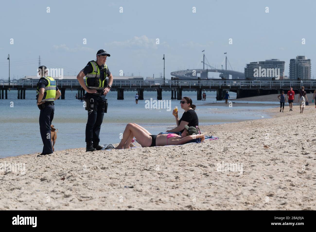 Die Polizeibehörden von Victoria erzwingen Strandschließungen am Middle Park Beach und sagen denen, die auf dem Sand liegen, dass sie nicht dort bleiben könnten, während andere Strände Stockfoto