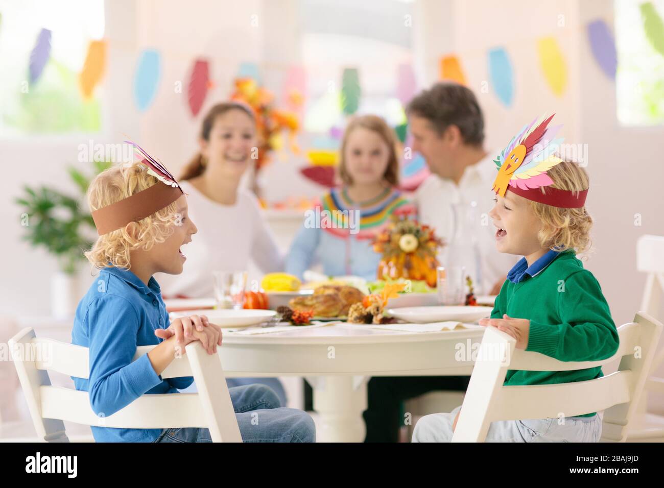 Familie mit Kindern, die Thanksgiving Abendessen essen. Geröstete truthahn- und Kürbiskuchen auf Esstisch mit Herbstdekoration. Festliche Mahlzeit für Eltern und Kinder. Stockfoto