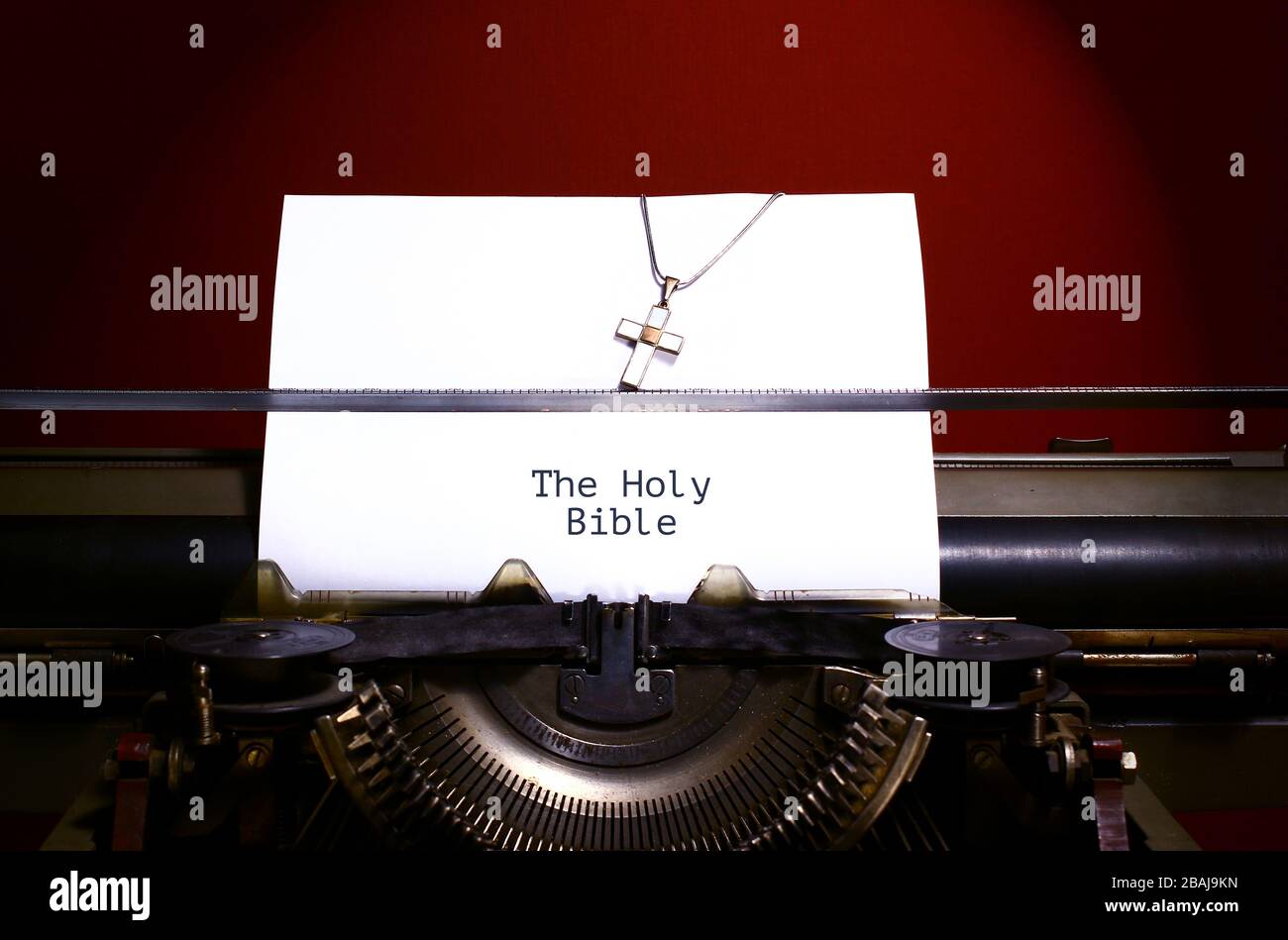 Heilige bibel auf Papier von alter Schreibmaschine geschrieben. Kette mit Kreuz Stockfoto