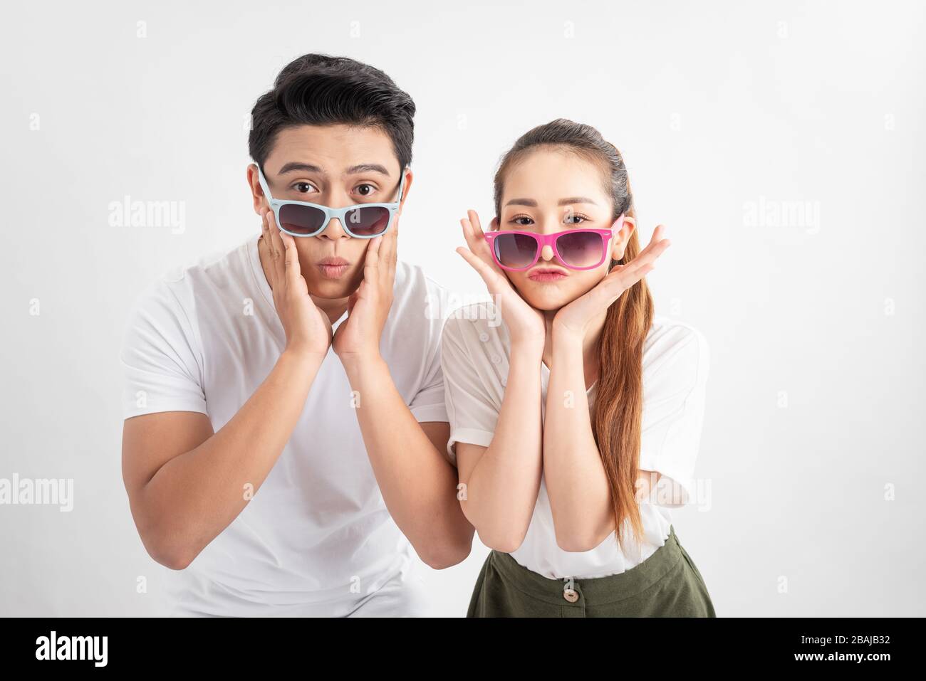 Nahaufnahme von zwei hübschen attraktiven liebenswürdigen fröhlichen Menschen Ehegattin in Brillen Brille berührt Wangen mit beiden Händen über weißen Backgroschen Stockfoto