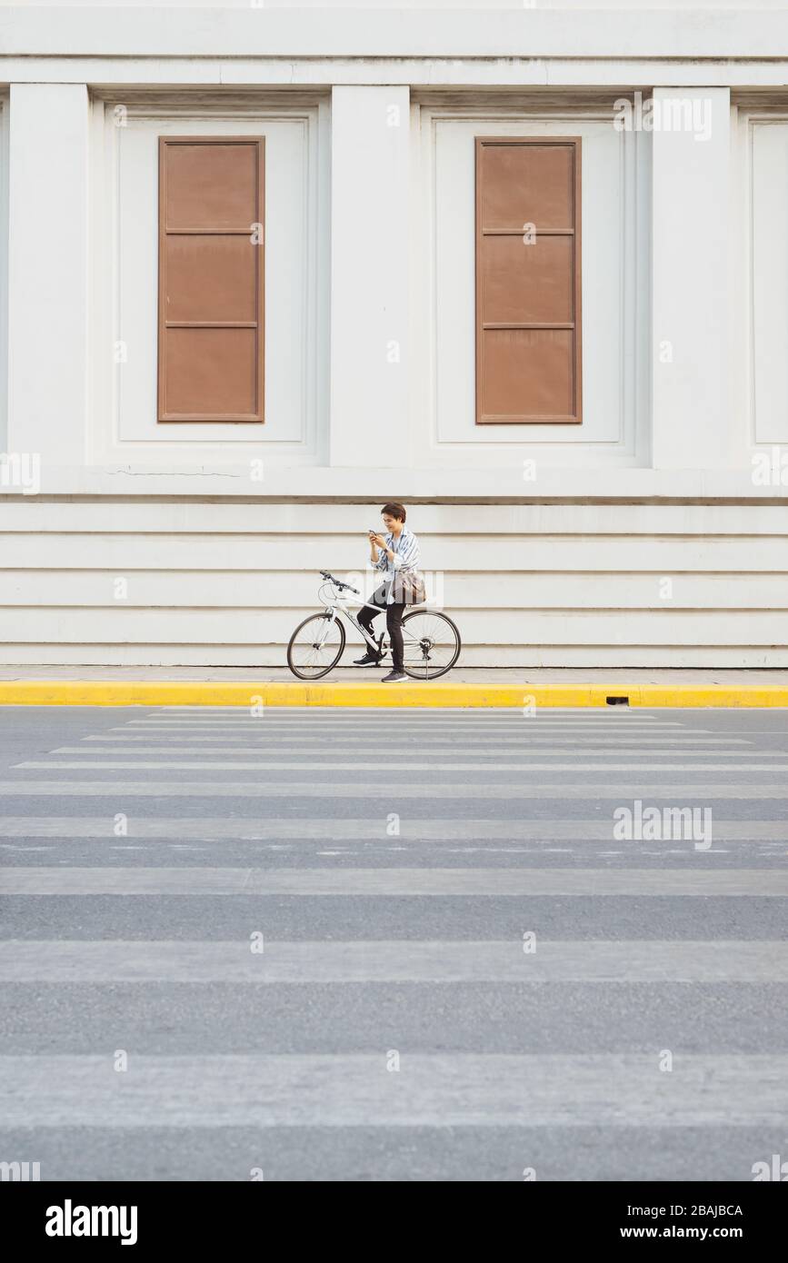Überall von seinem Fahrrad. Seitenansicht der junge Unternehmer freuen uns auf dem Fahrrad Stockfoto