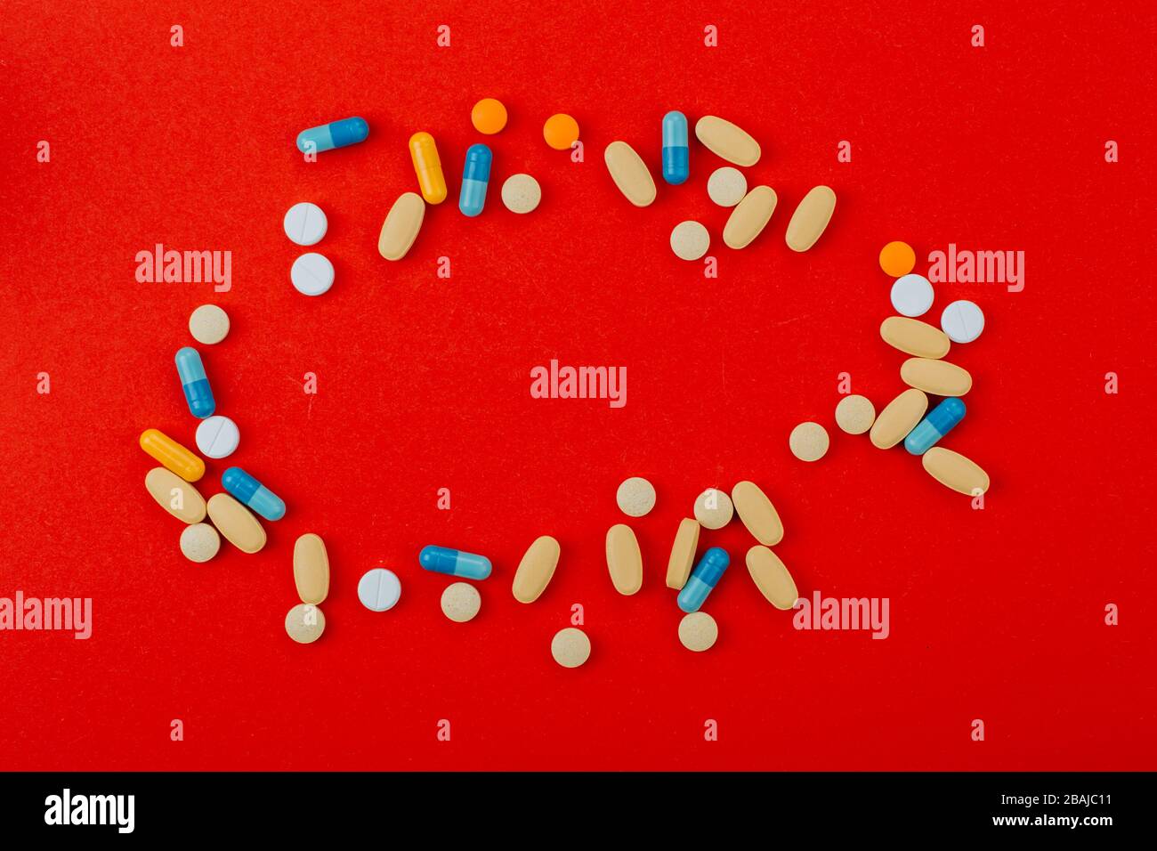 Verschiedene pharmazeutische Medikamente, Tabletten und Kapseln auf rotem Hintergrund. Stockfoto