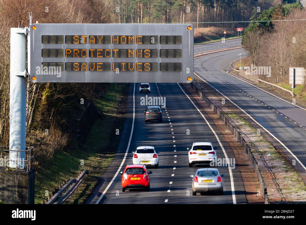 East Lothian, Schottland, Großbritannien. März 2020. Coronavirus Sperrschild am Straßenrand mit Meldung BLEIBEN ZU HAUSE SCHÜTZEN NHS RETTEN LEBEN auf DER AUTOBAHN A1 in East Lothian. Iain Masterton/Alamy Live News Stockfoto