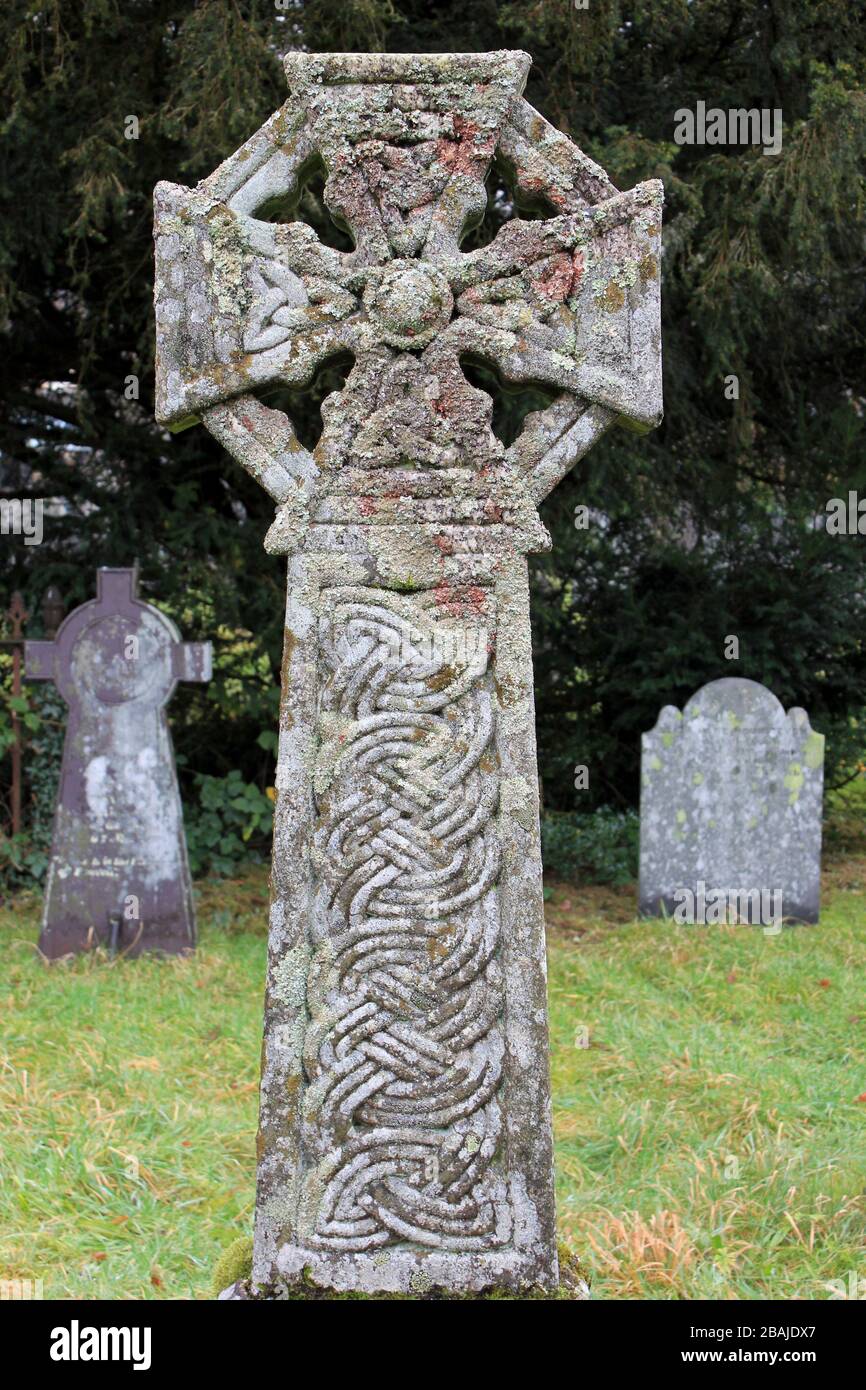 Kreuz mit Baumfolie und keltischen Knoten dekoriert und mit Flechten, Friedhof der St Michael's Old Church, Betws Y Coed, Conwy Valley, Wales bedeckt Stockfoto