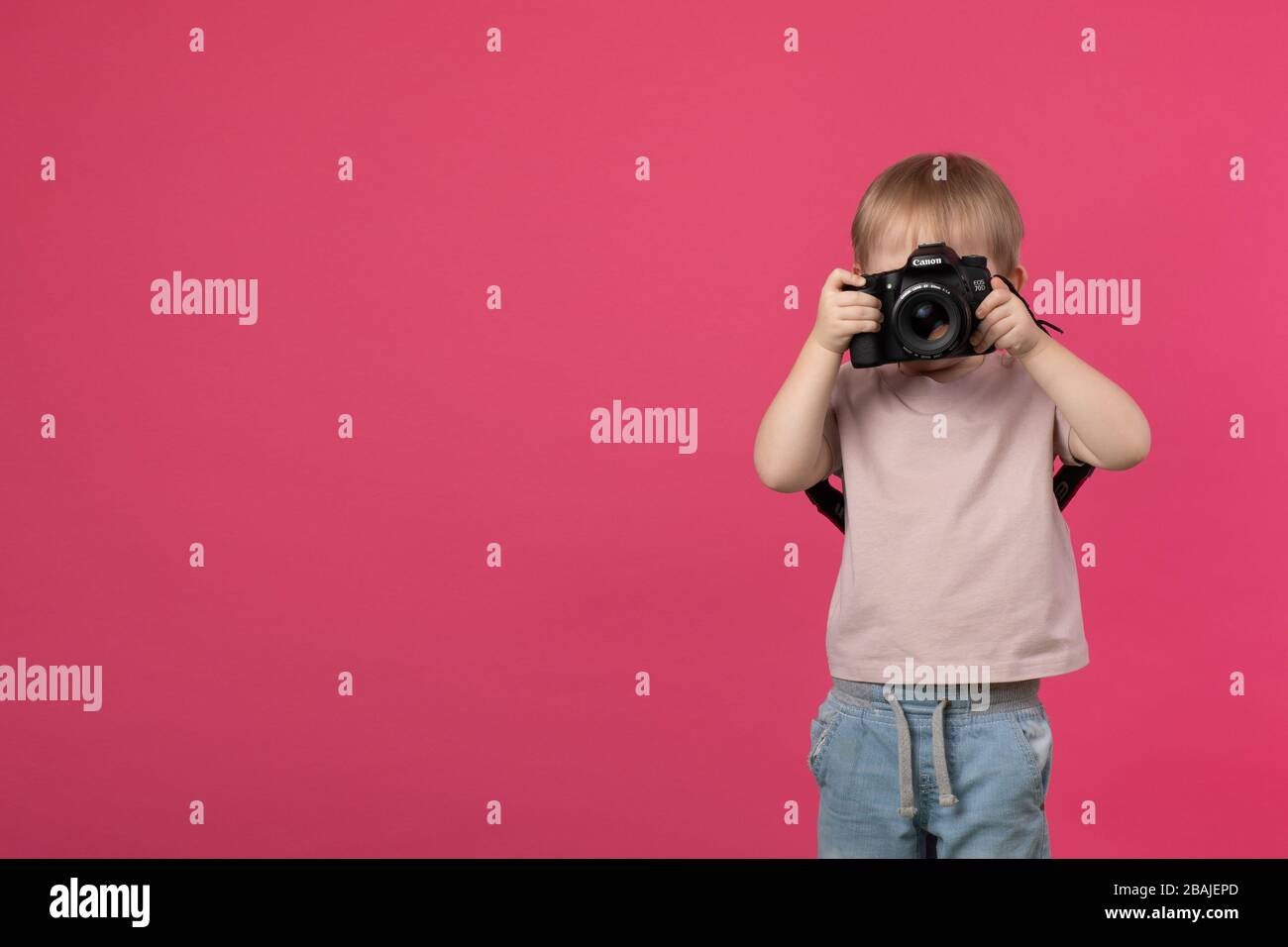 SANKT PETERSBURG, RUSSLAND - 22. MÄRZ 2020: Ein Kinderjunge steht und hält eine Canon 70d Kamera mit Objektiv mit EF 50 mm 1,4-Bajonett in den Händen Stockfoto
