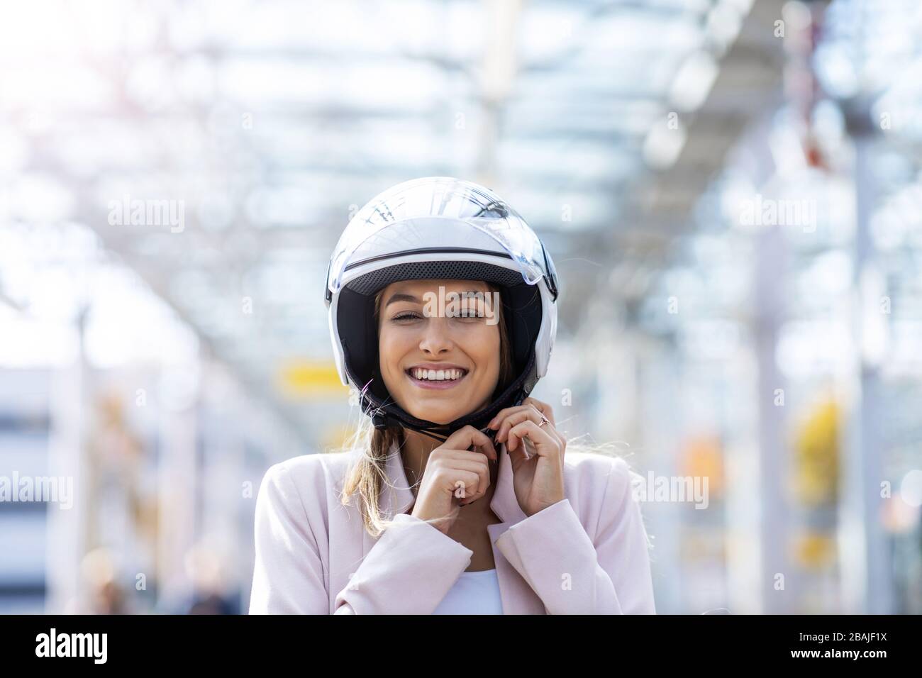 Frau im Helm mit Roller Stockfoto