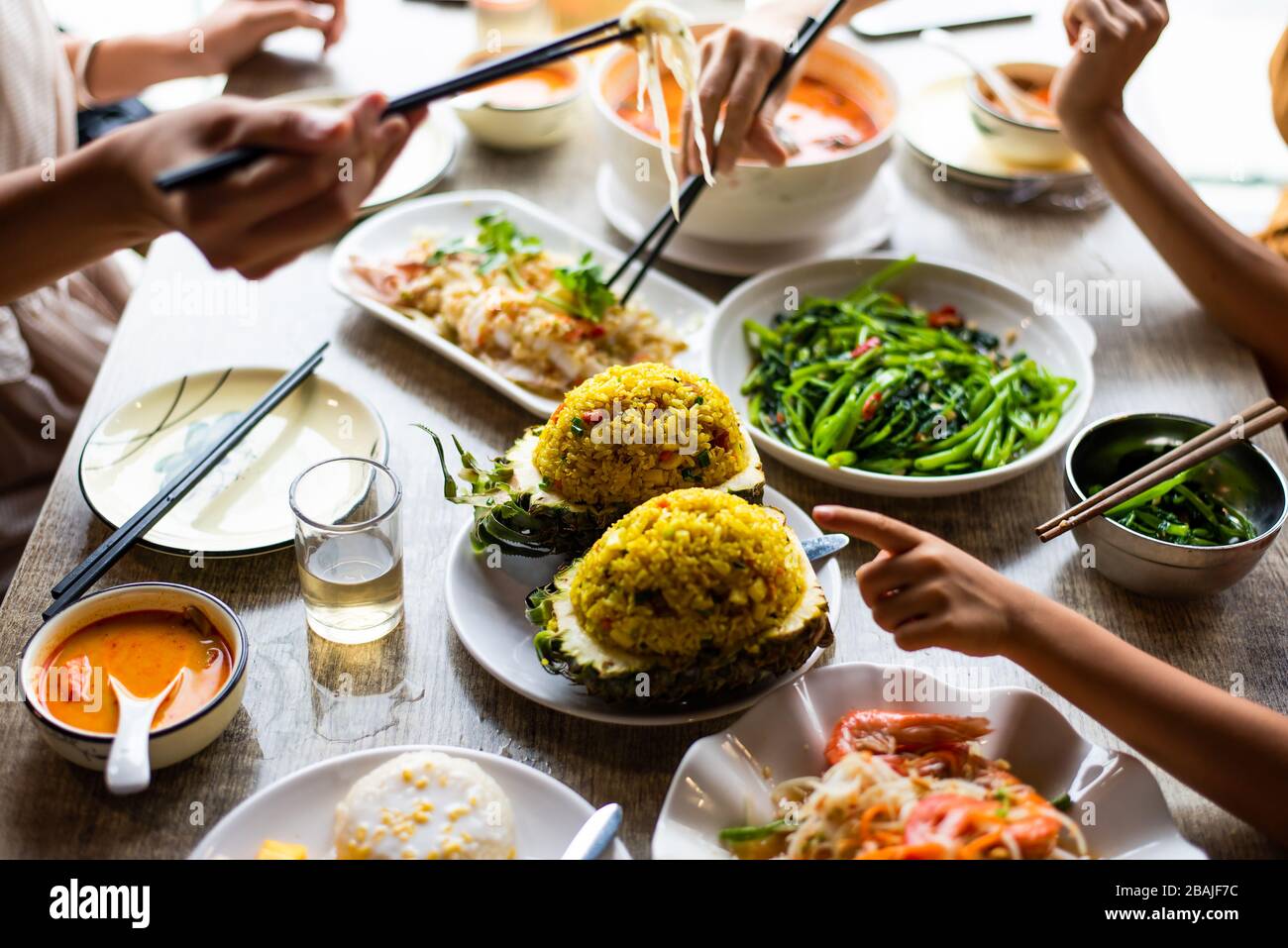 Leute, die im Restaurant ein großes thailändisches Essen essen Stockfoto