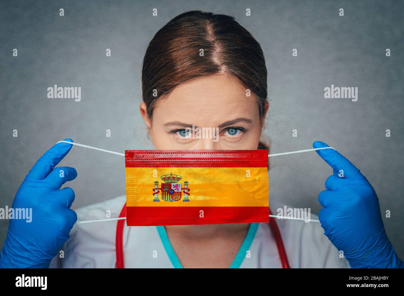 Coronavirus in Spanien, weiblicher Arzt Portrait Hold Protect Face Surgical Medical mask with Spain National Flag. Krankheit, Virus Covid-19 n Spanien, Schein Stockfoto