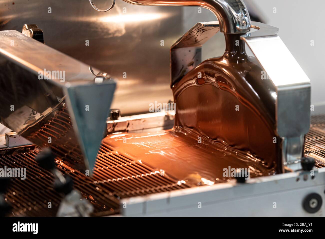 Industriemaschine zur Verdeckung mit süßer Schokolade Stockfoto