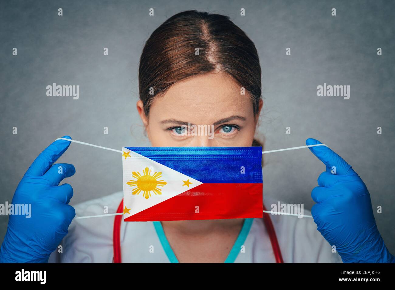 Coronavirus auf den Philippinen Frauenarzt Porträt halten Gesicht schützen chirurgische Maske mit Philippinen National Flag. Krankheit, Virus Covid-19 in P Stockfoto