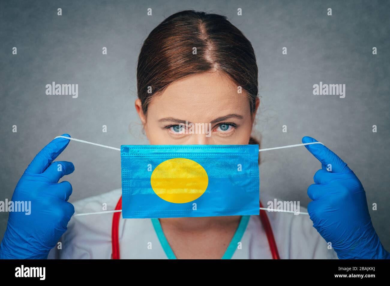 Coronavirus in Palau Female Doctor Portrait Hold Protect Face Surgical Medical mask with Palau National Flag. Krankheit, Virus Covid-19 in Palau, Schein Stockfoto