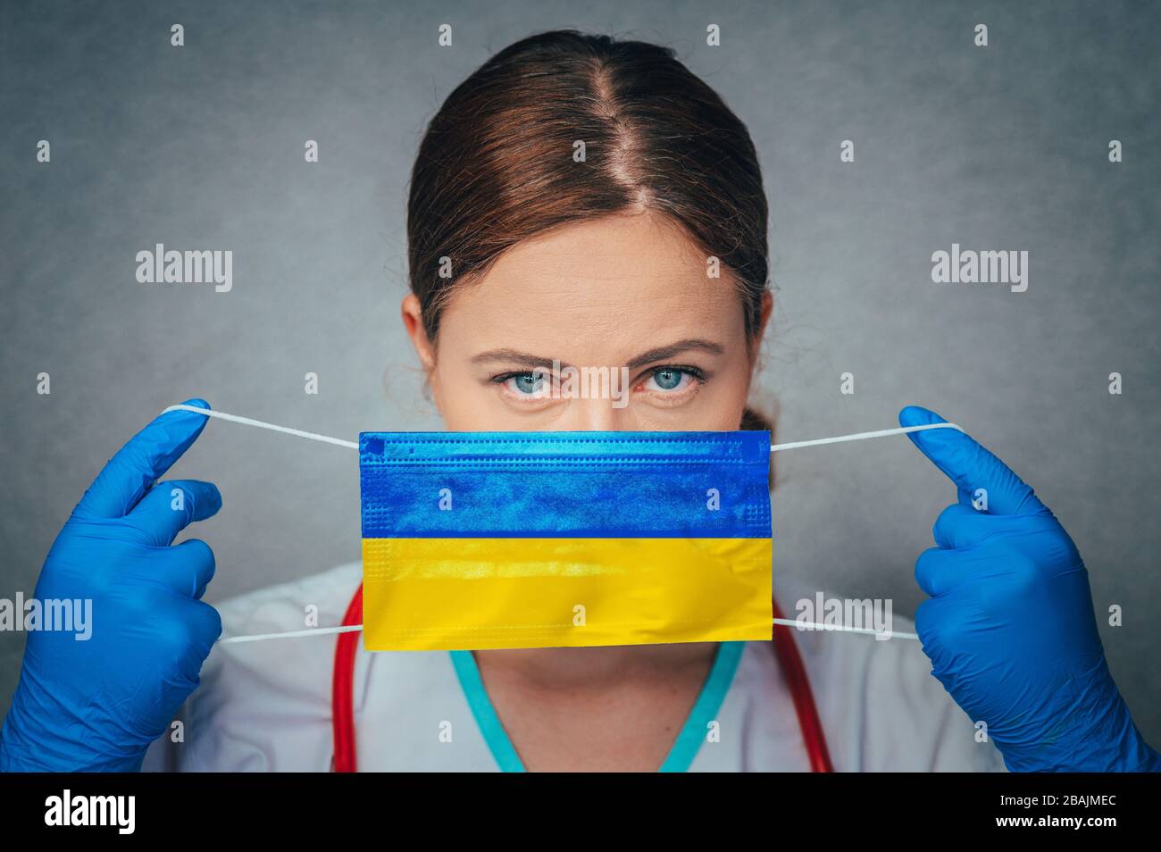 Coronavirus in der Ukraine Frauenarzt Porträt halten Gesicht schützen chirurgische Maske mit Ukraine Nationalflaggen. Krankheit, Virus Covid-19 in der Ukraine, Stockfoto