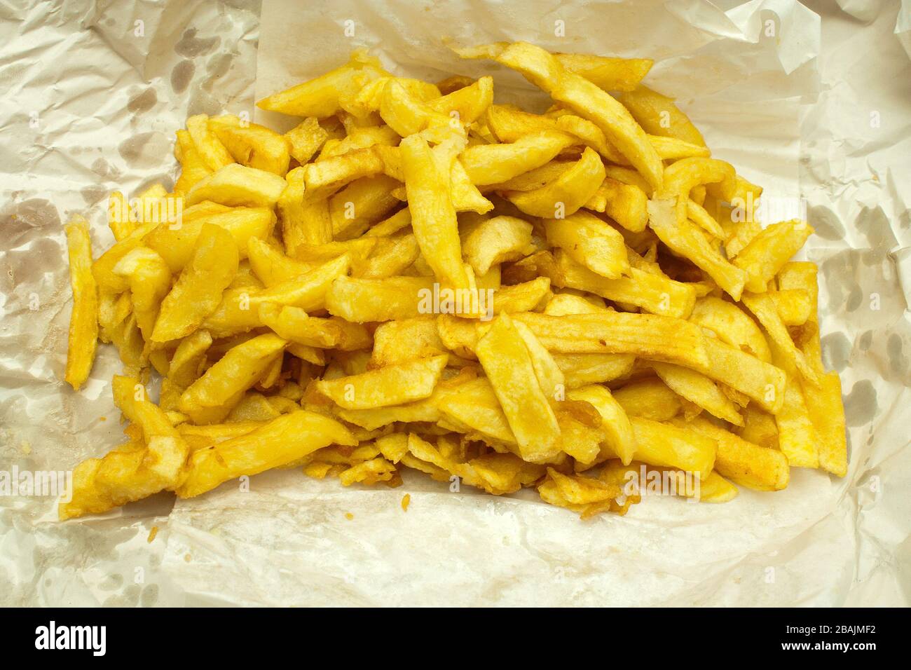 Chips wurden in Papier aus einem traditionellen britischen Chip-Shop verpackt serviert Stockfoto