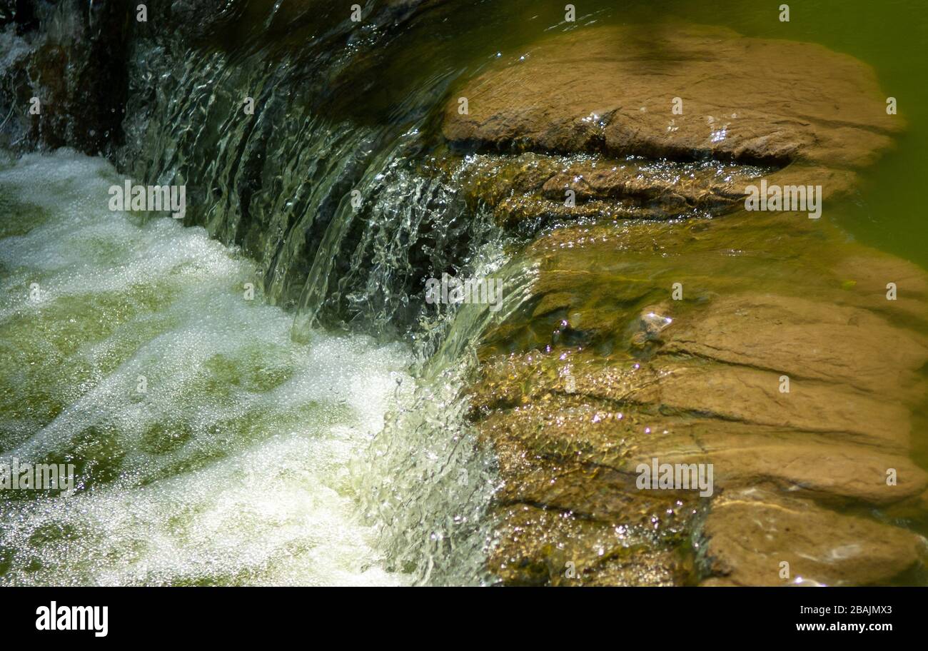 Wasser fließt in den Teich, der zentral zum städtischen Hong Kong Park auf der Insel, Hongkong SAR, China, führt Stockfoto