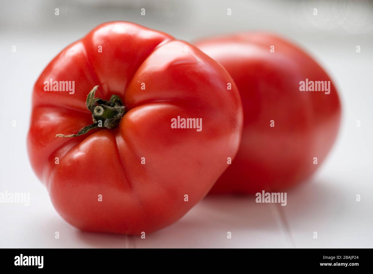 Nahaufnahme von zwei Tomaten auf weißem Tisch. Natürliche Farbe. Stockfoto