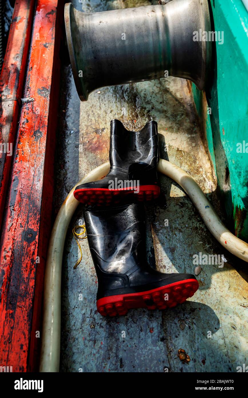 Fischer schwarzen Gummistiefel mit roter Sohle auf Bootsboden  Stockfotografie - Alamy