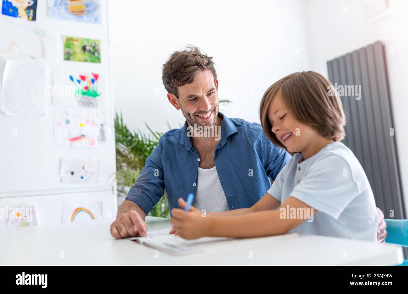 Vater und Sohn gemeinsam Hausaufgaben zu machen wie zu Hause. Stockfoto