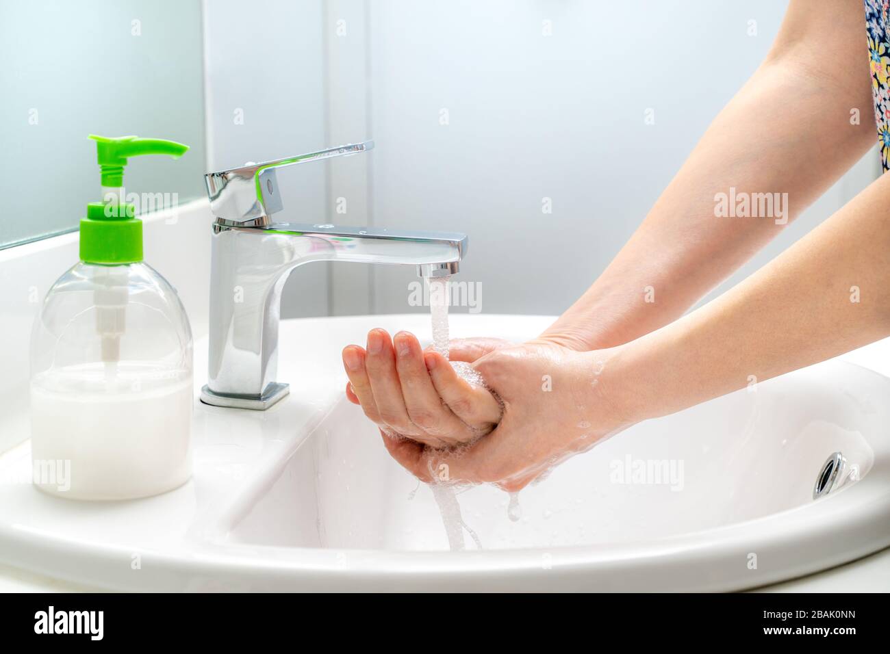 Frau, die ihre Hände mit Seife an der Spüle waschen, um gute Hygiene zu gewährleisten und um ein Kovid-19-Virus zu verhindern Stockfoto