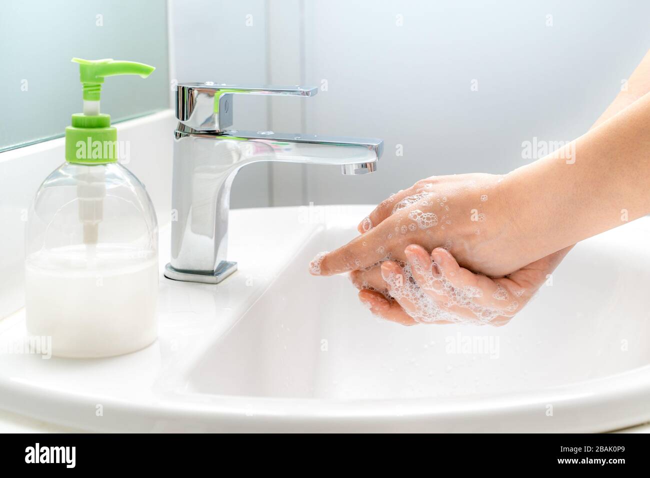 Frau, die ihre Hände mit Seife an der Spüle waschen, um gute Hygiene zu gewährleisten und um ein Kovid-19-Virus zu verhindern Stockfoto