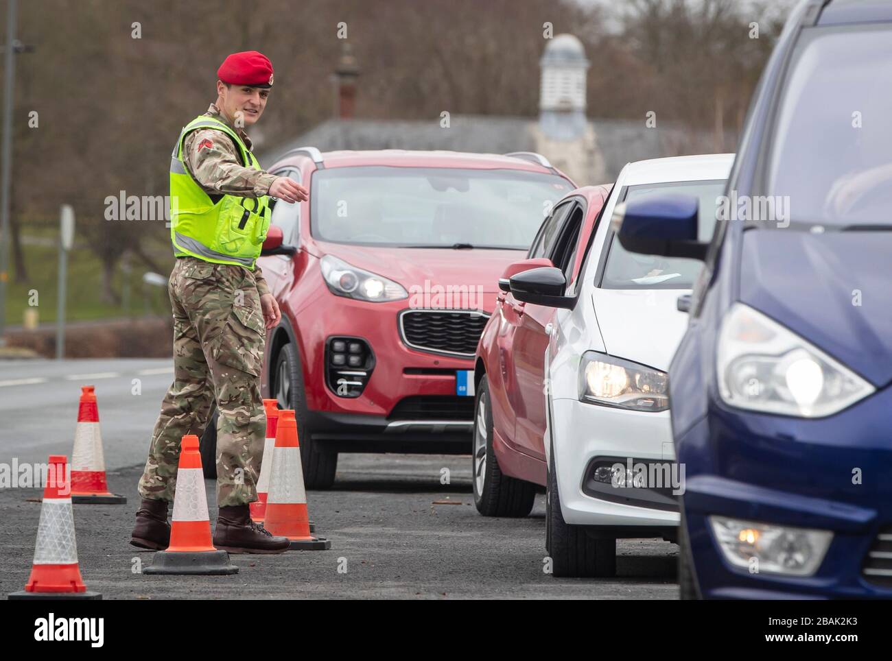 Ein Mitglied der Royal Military Police 150 Provost Company arbeitet neben der Polizei von North Yorkshire an einem Fahrzeugprüfpunkt in der Nähe der Catterick Barracks in Yorkshrie, um sicherzustellen, dass Autofahrer behördliche Auflagen einhalten und nur wichtige Reisen Unternehmen. Stockfoto