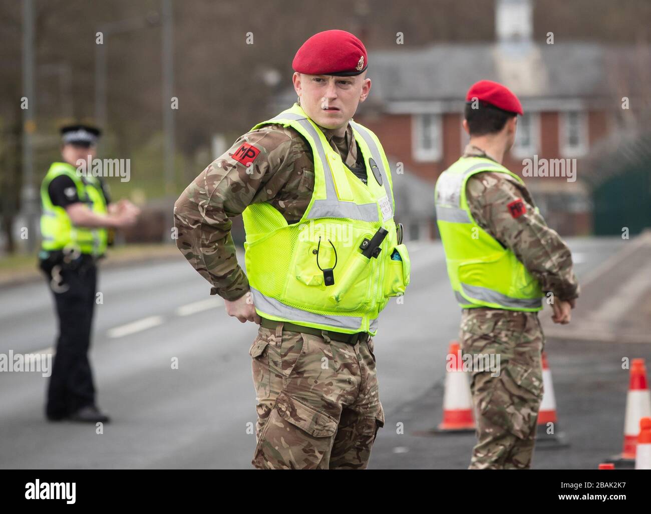 Mitglieder der Royal Military Police 150 Provost Company arbeiten neben der Polizei von North Yorkshire an einem Fahrzeugprüfpunkt in der Nähe der Catterick Barracks in Yorkshrie, um sicherzustellen, dass Autofahrer behördliche Auflagen einhalten und nur wichtige Reisen Unternehmen. Stockfoto