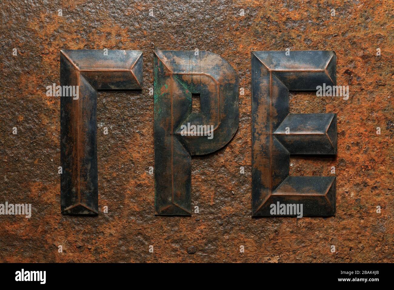 Hintergründe und Texturen: Eine Gruppe von gealterten, geprägten kyrillischen Kupferbuchstaben auf stark korrodierten rostigen Metalloberflächen Stockfoto