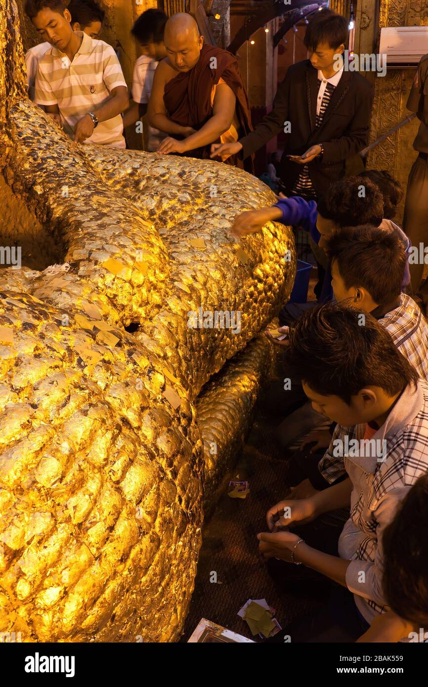 Männliche Anhänger, die goldene Blätter an der Mahamuni-Buddha-Statue, Mandalay, Myanmar, anbringen Stockfoto