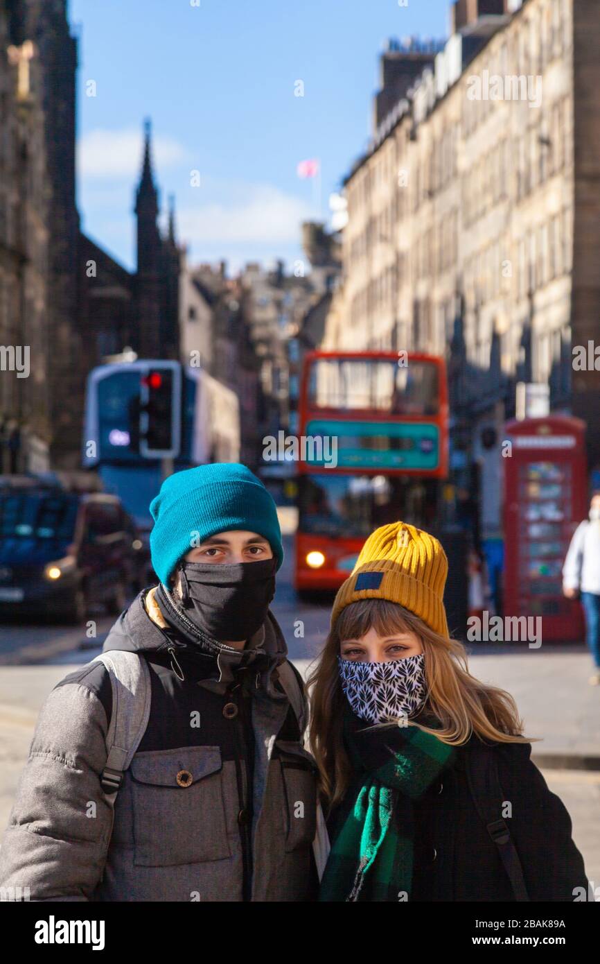 Touristen, die Gesichtsmasken auf der Royal Mile während der Coronavirus Pandemie Lockdown März 2020 tragen Stockfoto